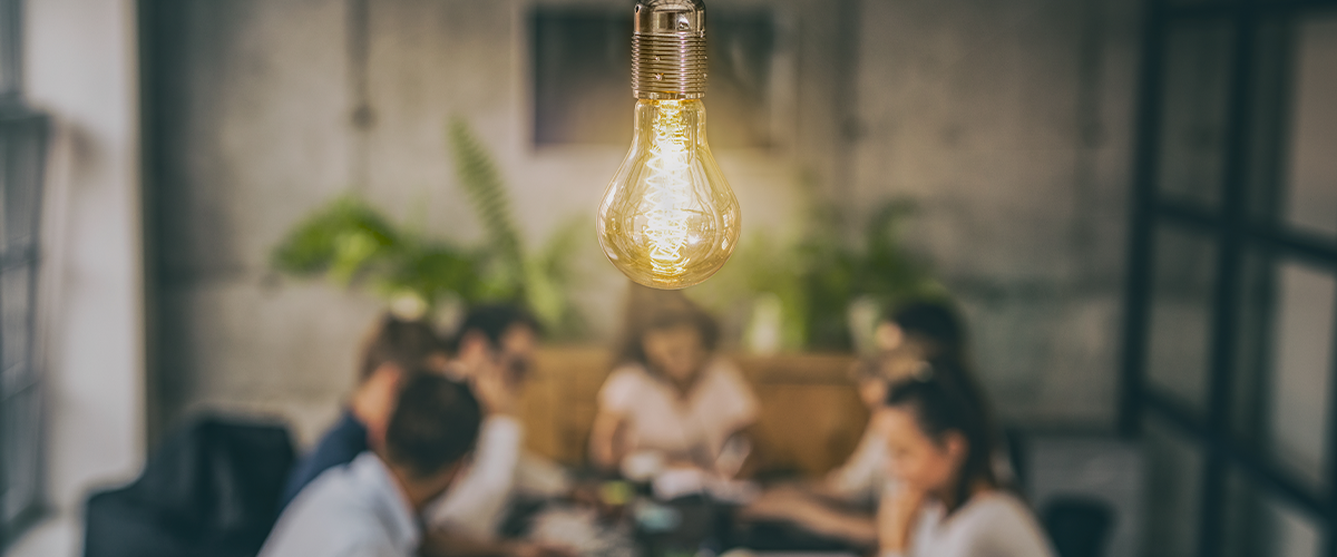 People at a table with a light bulb hanging in front of them